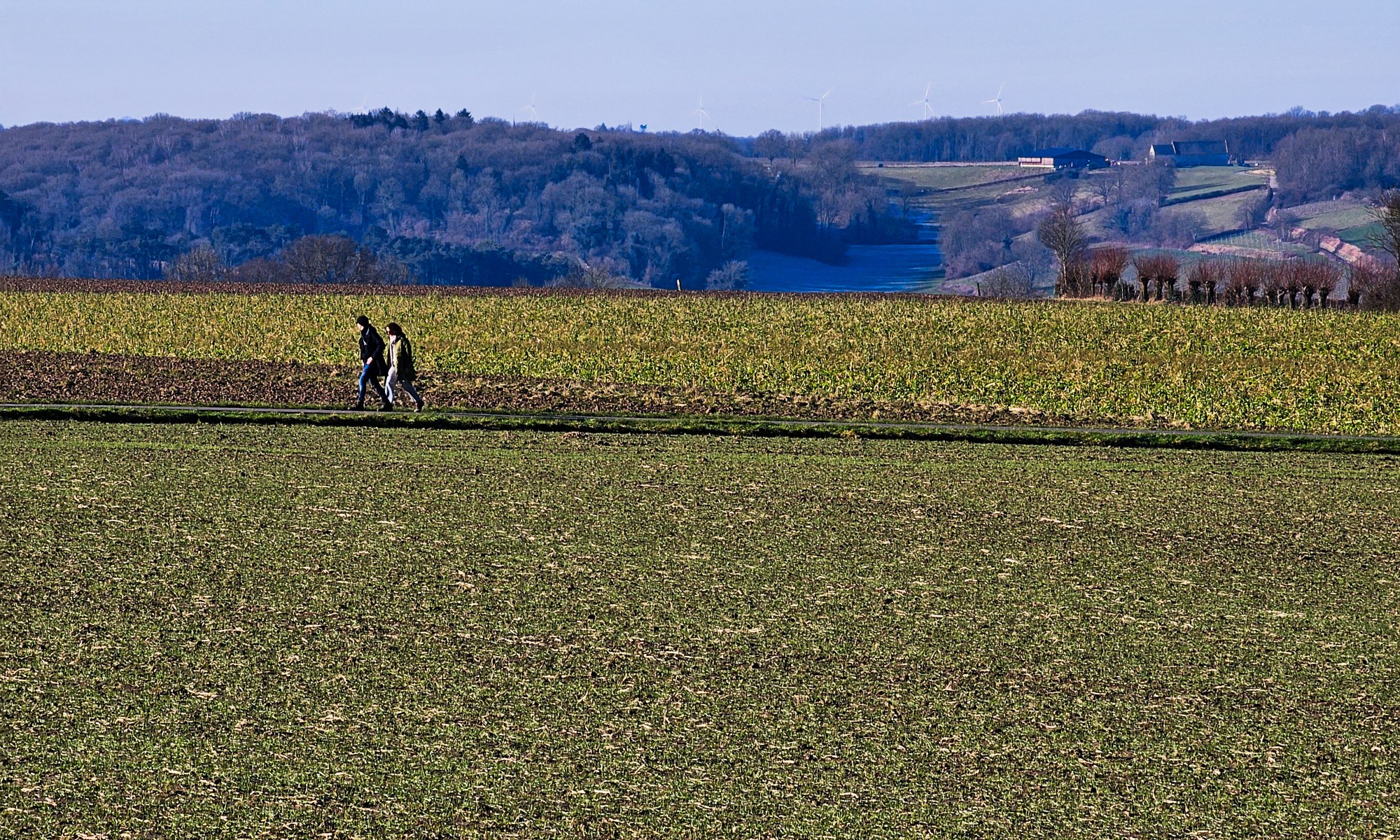 Two Walkers on a Plateau in vast Landscape, Hillside in the Distance